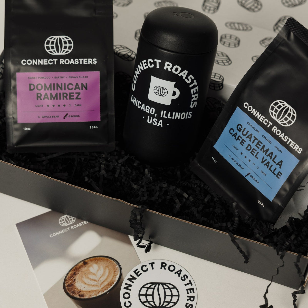 The Commuter gift box, open, with the travel mug between two bags of coffee